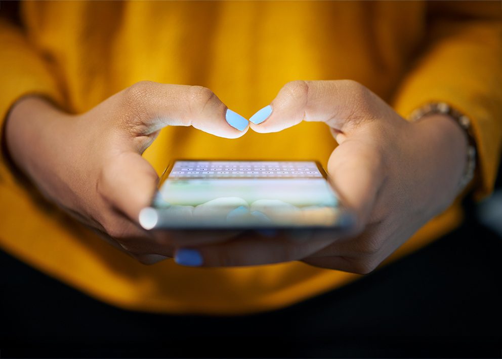 Detailaufnahme einer Frau, die ein Smartphone in den Händen hält, als Symbol für das Thema KI im Wahlkampf