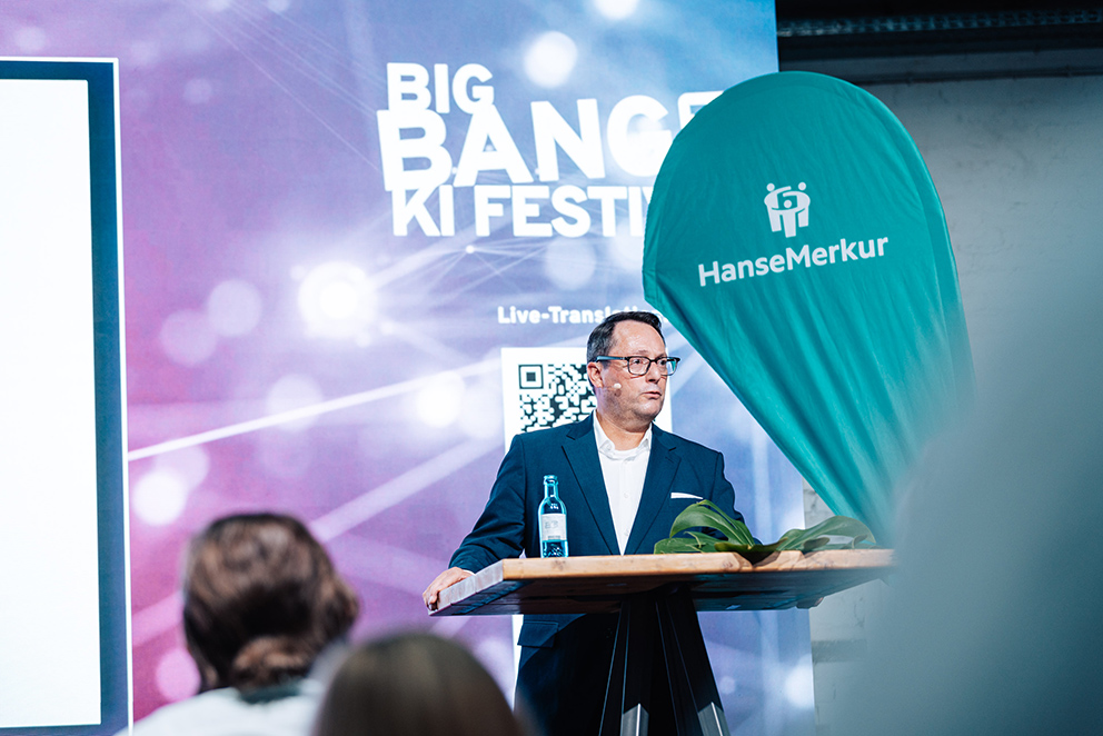 Eric Bussert auf der Bühne des BIG BANG KI FESTIVALS während eines Vortrags über KI in der Medizin