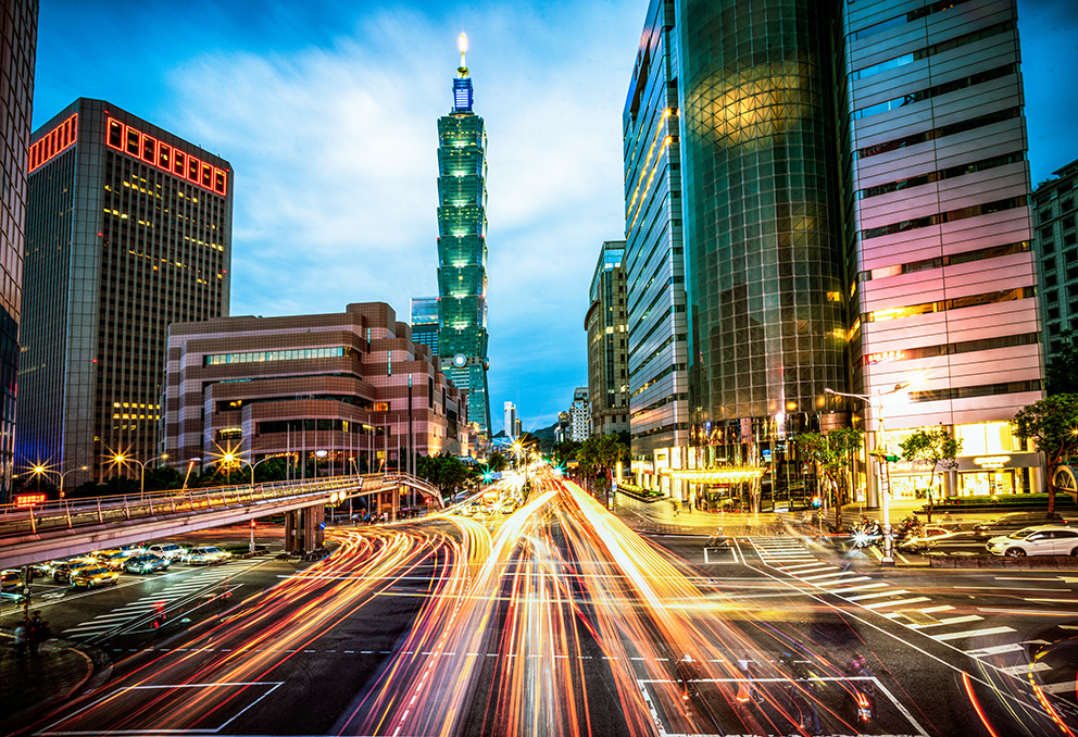 Nächtliche Straße und Skyline einer asiatischen Großstadt als Symbolbild für Investment im Raum Asien-Pazifik