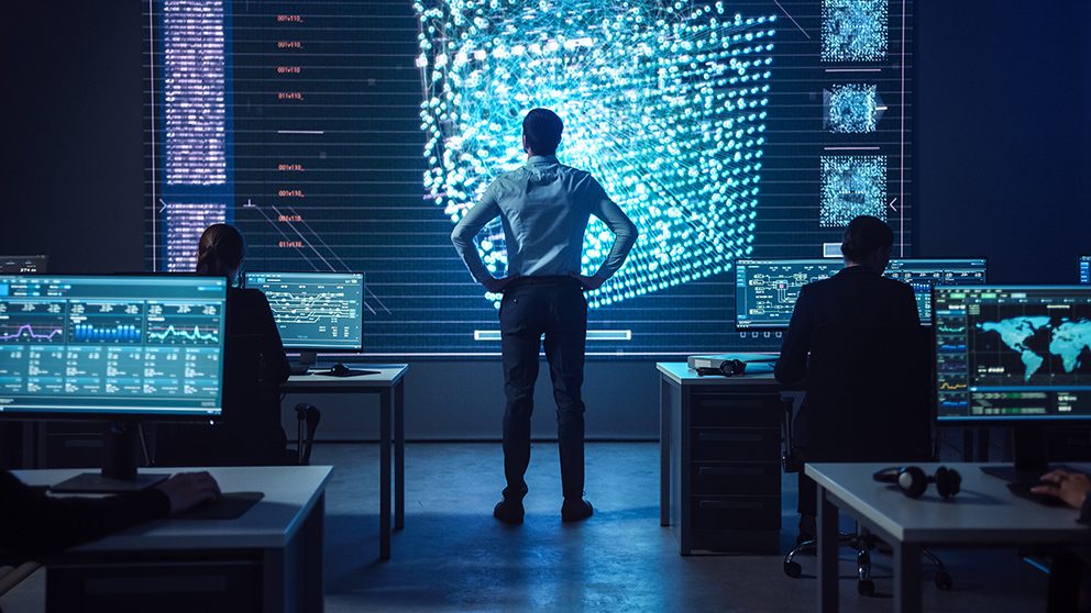Einblick in ein futuristisches Büro, in dem ein Mann in Businesskleidung auf einen großen Bildschirm schaut, als Symbol für das Thema Agentic Marketing