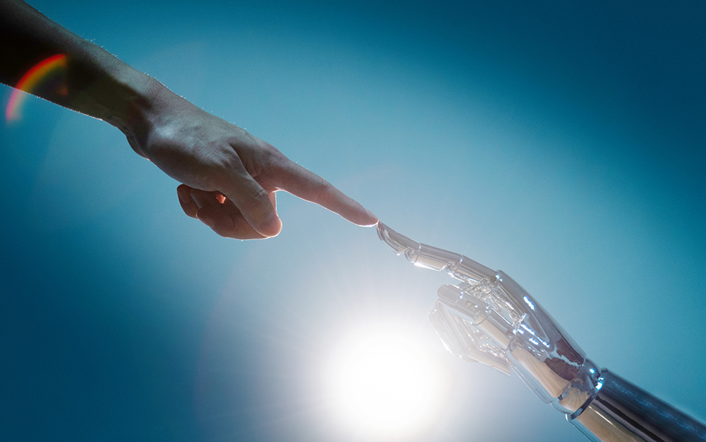 Eine menschliche und eine Roboterhand berühren sich am Zeigefinger, als Symbol für Vertrauen in KI
