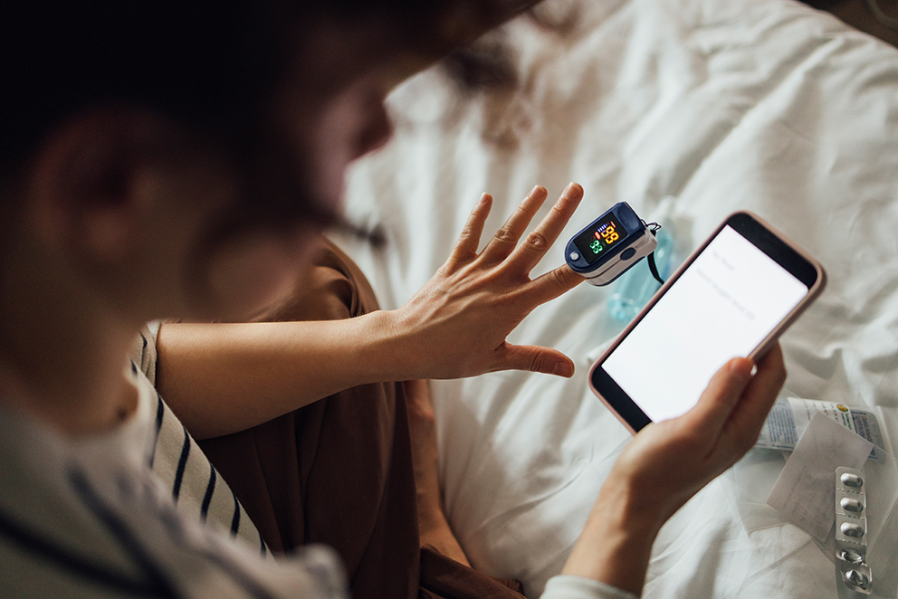 Eine Person misst ihren Blutzuckerspiegel und schaut dabei auf ihr Smartphone, als Symbol für das Thema Personal AI