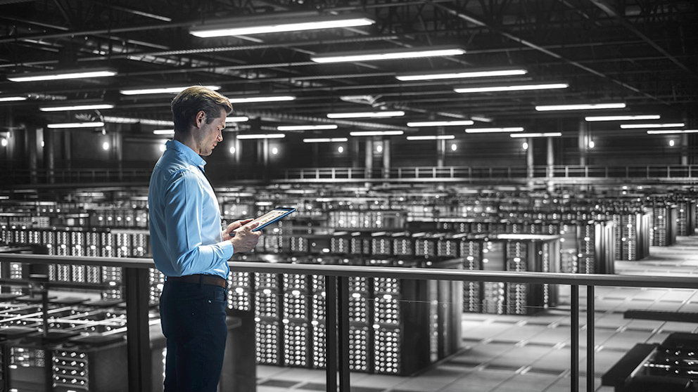 Ein Mann in Businesskleidung in einer Produktionshalle, als Symbol für Tech-Aktien