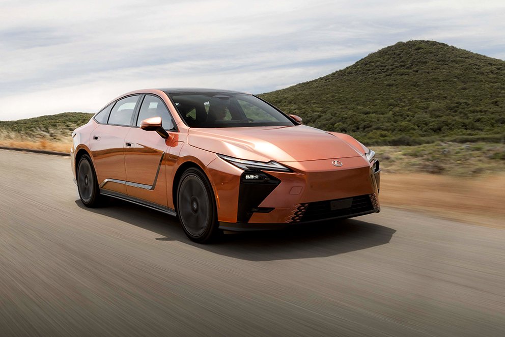 Ein orangefarbener Lexus ES fährt durch eine Landschaft.